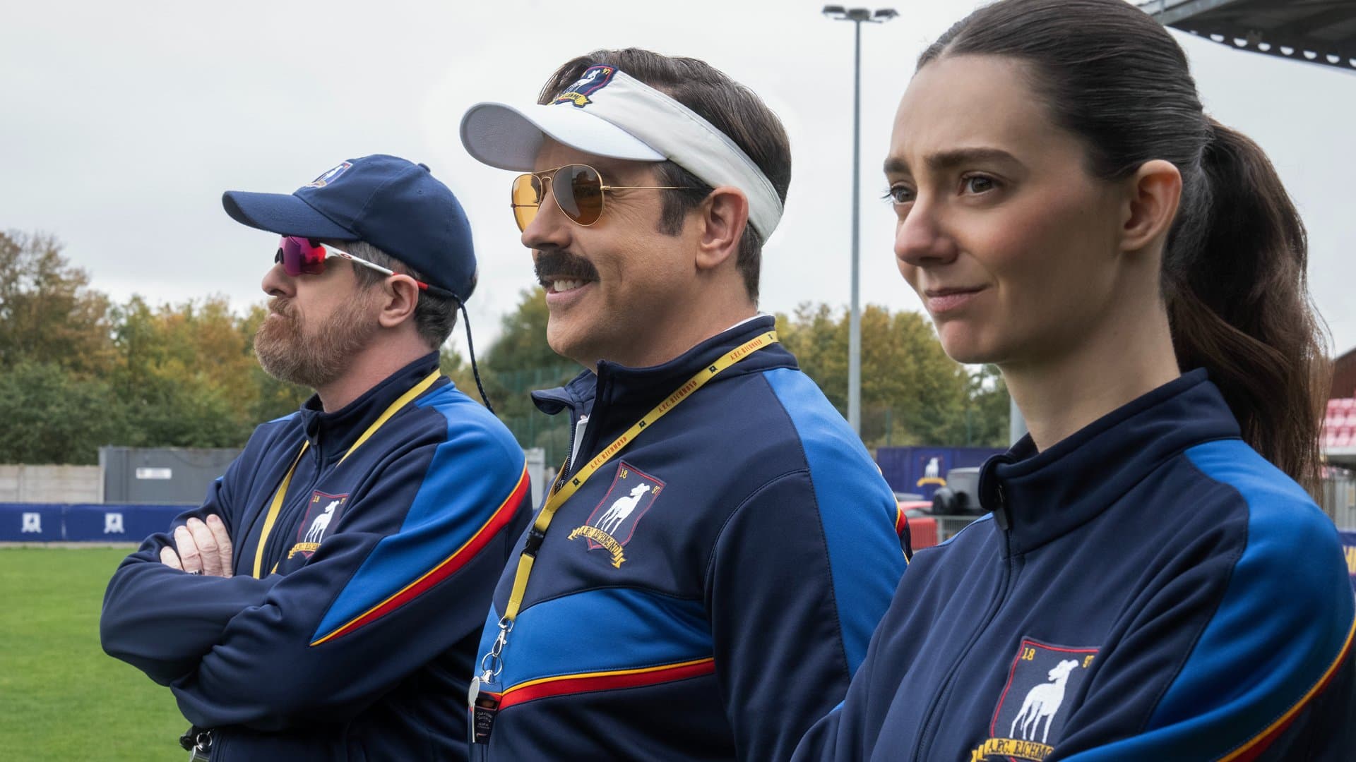 Ted Lasso (Jason Sudeikis, center) faces an entirely new challenge in Season 4, which he approaches with his usual optimism.